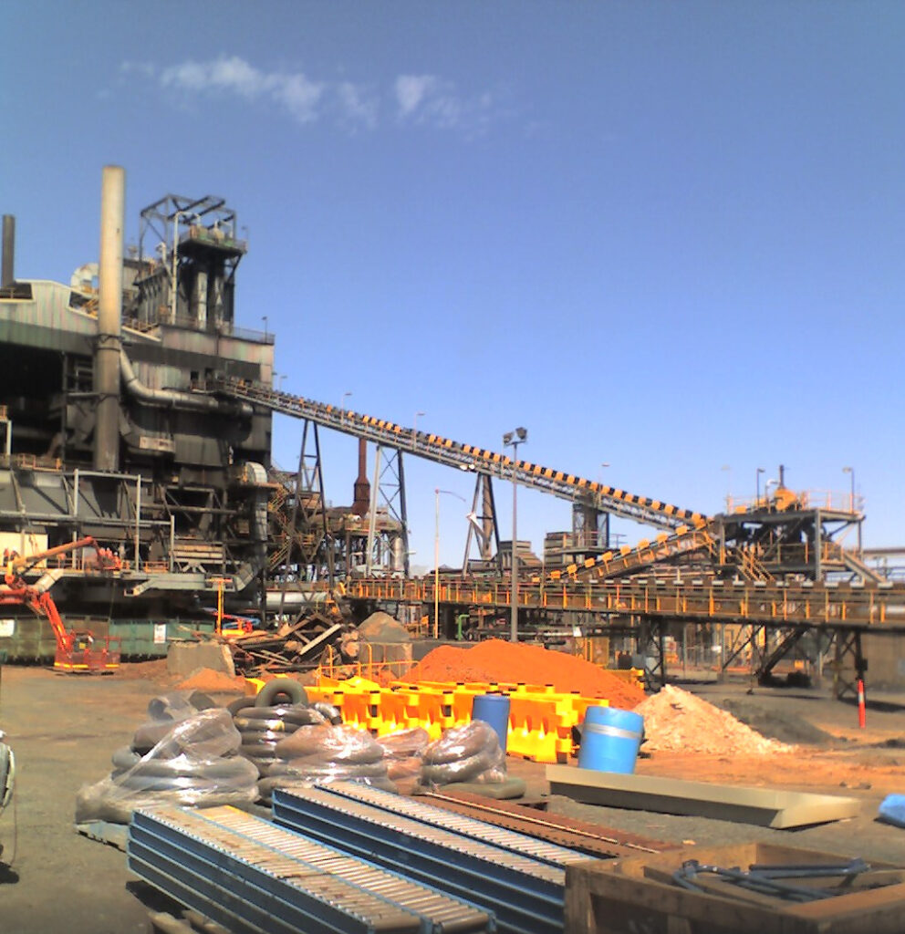 An image of a mine site, showing conveyors, a smelter, and some material stored for the project, waiting for installation and use.