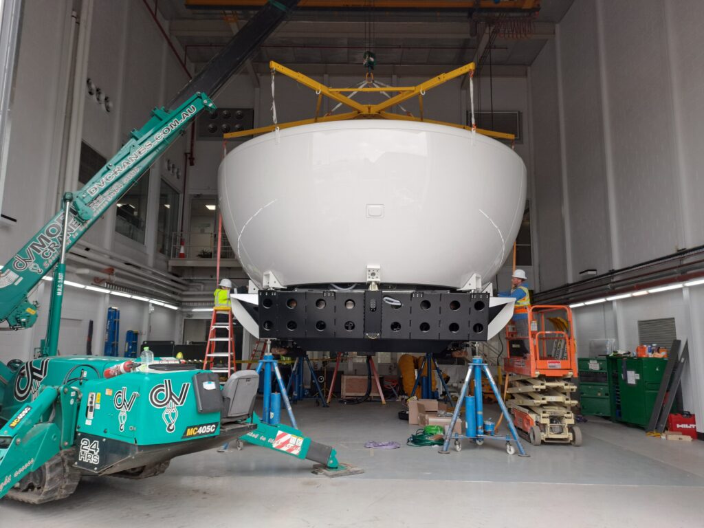 Tight access lifting. A pilot training flight simulator being installed, using specialised lifting frame