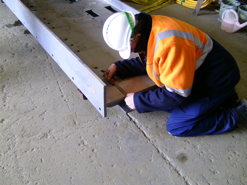 An image of an employee marking out some steel