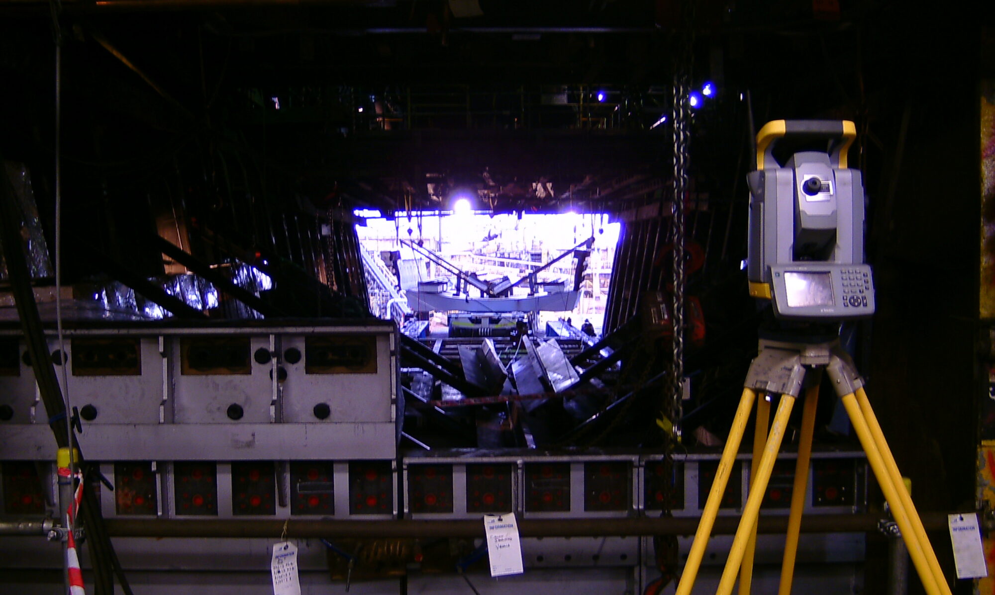 An image of a dumpy level looking over a steel site's construction.